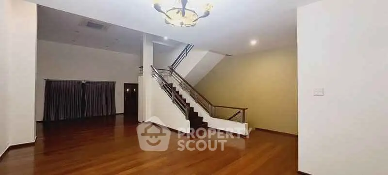 Spacious modern living room with elegant staircase and wooden flooring