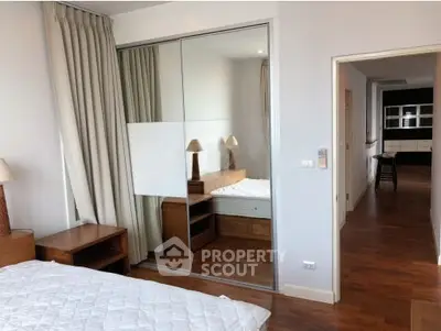 Spacious bedroom with mirrored closet and wooden flooring in modern apartment