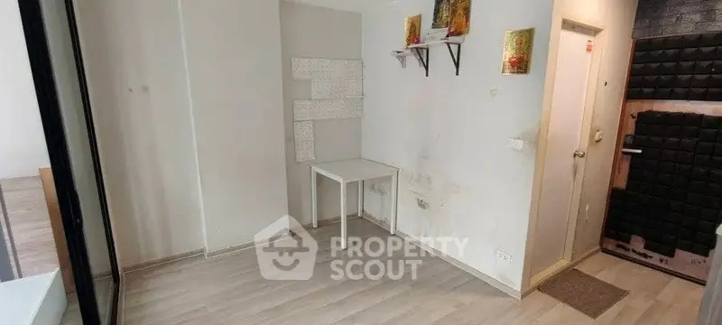 Minimalist interior space with light wood flooring and small table, ideal for creative design.