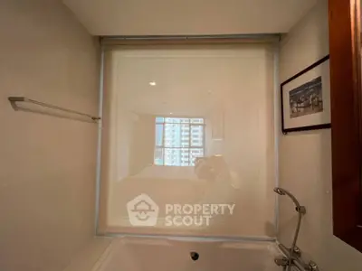 Luxurious bathroom with modern bathtub and city view window, perfect for relaxation.
