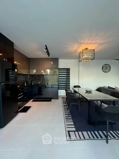 Modern open-layout kitchen with sleek black cabinetry and stylish dining area