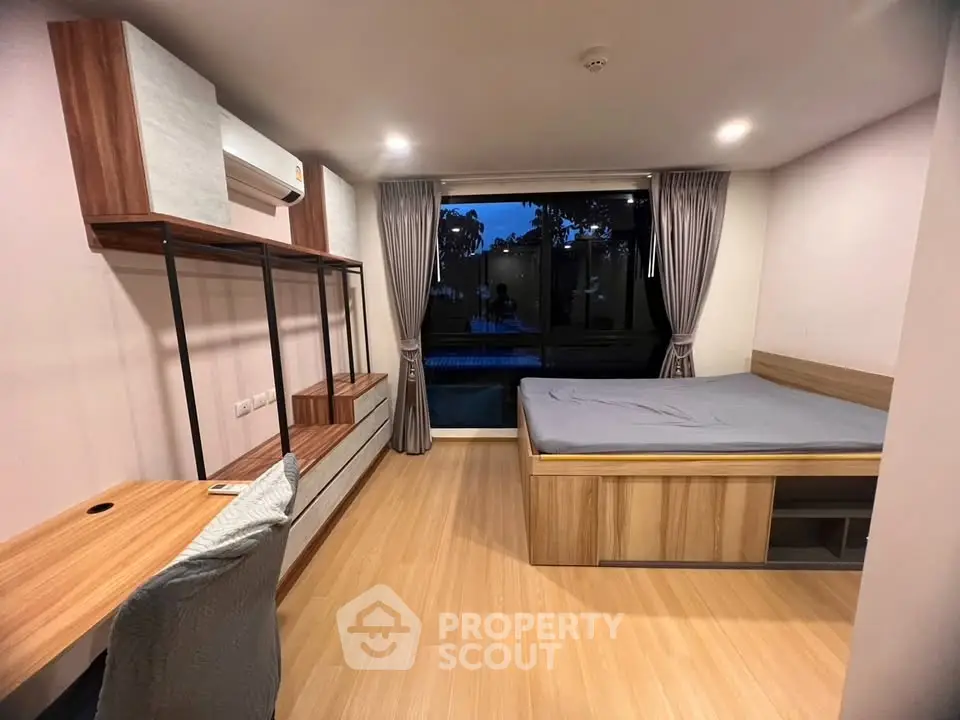 Modern bedroom with large window and stylish wooden furniture, offering a cozy and inviting atmosphere.