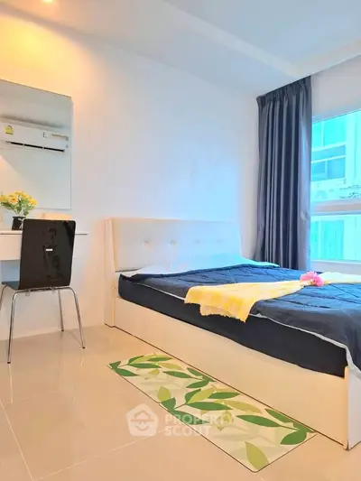Modern bedroom with stylish decor and large window offering natural light.