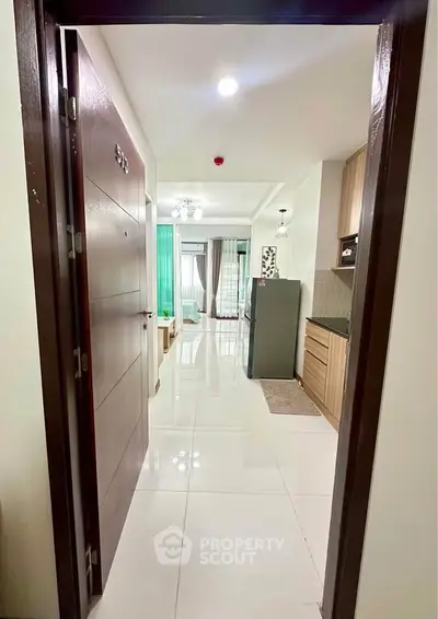 Modern apartment entrance with sleek kitchen and bright living area