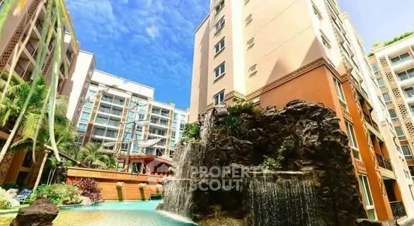 Luxurious apartment complex with stunning waterfall feature and lush landscaping.