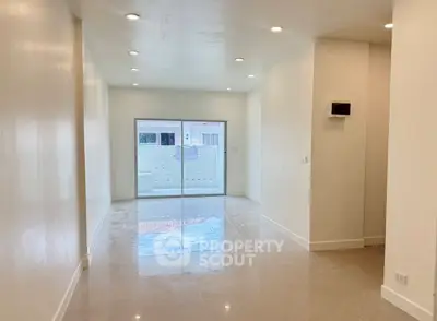 Spacious modern living room with glossy tile flooring and recessed lighting