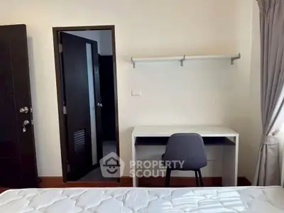 Cozy bedroom with desk and chair, ideal for study or work from home setup.