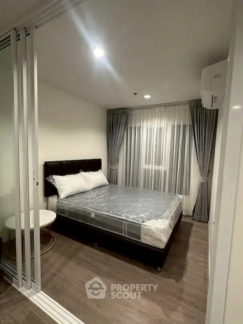 Modern bedroom with sleek design and large window for natural light.