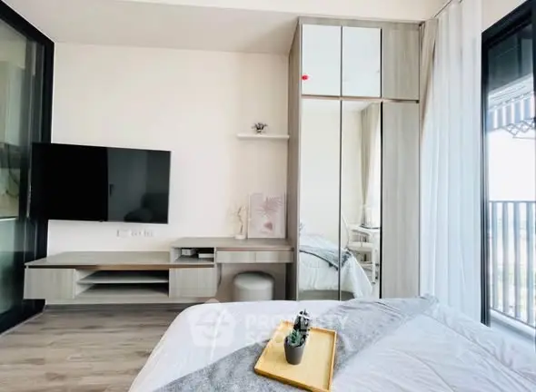 Modern bedroom with sleek design and balcony view, featuring stylish furniture and decor.