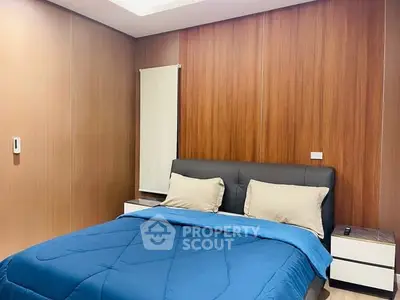 Modern bedroom with wooden panel walls and cozy blue bedding