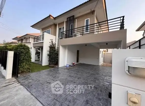 Modern two-story house with spacious driveway and balcony in suburban neighborhood.