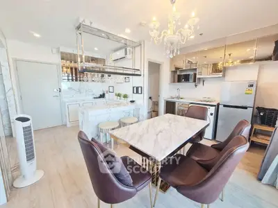 Luxurious modern kitchen and dining area with marble countertops and elegant chandelier