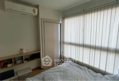 Cozy bedroom with air conditioning and natural light through vertical blinds.
