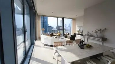 Luxurious modern living room with stunning city view and elegant dining area.