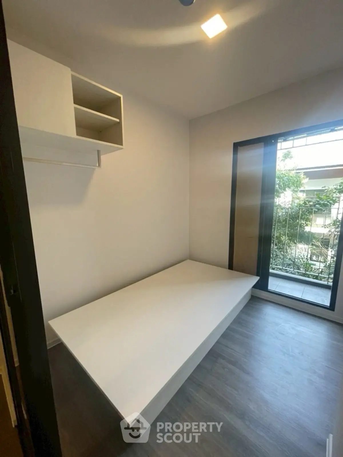 Minimalist bedroom with platform bed and balcony view