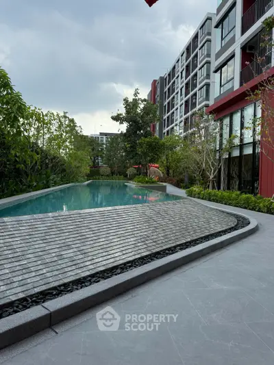 Modern apartment complex with a stylish outdoor pool and lush greenery, perfect for luxury living.