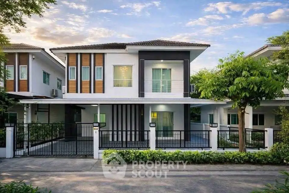Modern two-story house with sleek design and spacious driveway in a serene neighborhood.
