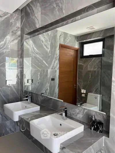 Luxurious modern bathroom with dual sinks and marble walls