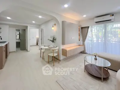 Modern open-plan living room with dining area, featuring stylish decor and natural light.