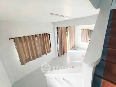 Bright and spacious living room with large windows and modern curtains, perfect for natural light lovers.