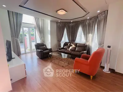 Spacious living room with elegant curtains and modern furniture, featuring a cozy seating area and natural light.