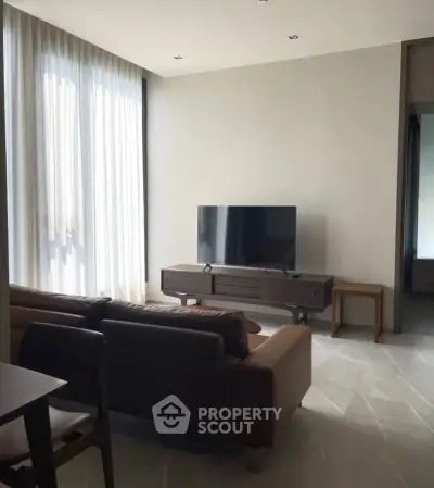 Modern living room with sleek furniture and large windows for natural light.