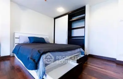 Modern bedroom with sleek storage bed and wooden flooring