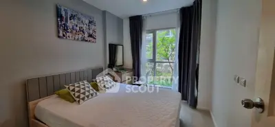Cozy bedroom with modern decor, large window, and garden view in a stylish apartment.