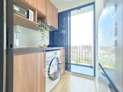 Modern kitchen with washing machine and balcony view in a stylish apartment.