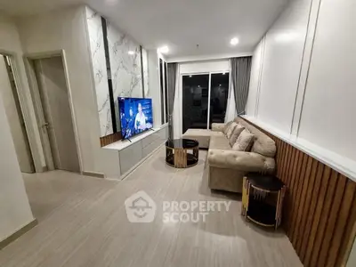 Modern living room with stylish decor and large TV, featuring a cozy sofa and elegant design.