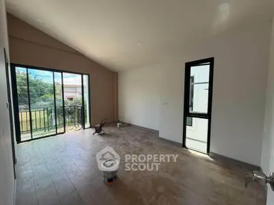 Spacious unfurnished room with large windows and balcony access, perfect for customization.
