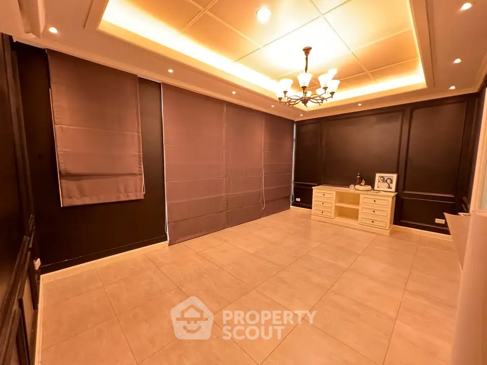 Spacious empty room with elegant lighting and tiled flooring, ideal for versatile interior design.