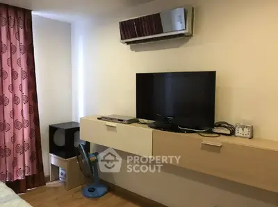 Cozy living room with modern TV setup and stylish wall-mounted shelf.