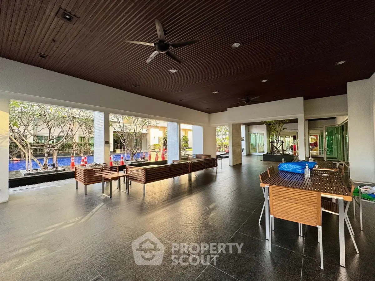 Spacious outdoor area with modern seating and ceiling fans, perfect for relaxation and gatherings.