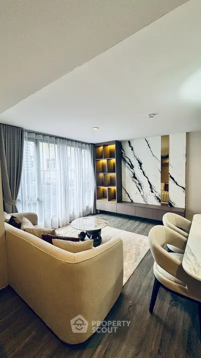 Luxurious modern living room with elegant marble accents and floor-to-ceiling windows.