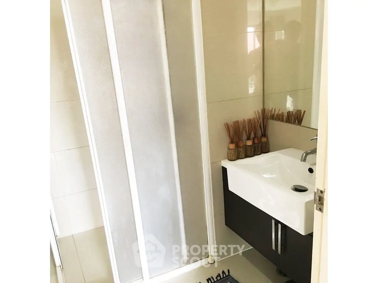 Modern bathroom with sleek shower and stylish sink in a contemporary home.