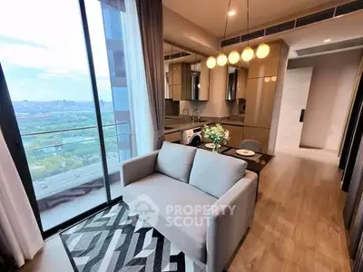 Modern living room with open kitchen and stunning city view from balcony.
