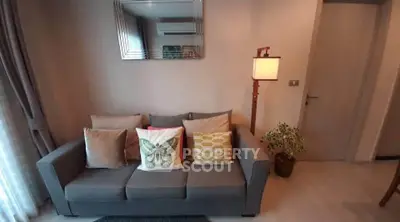 Cozy living room with stylish sofa and decorative pillows, perfect for relaxation.