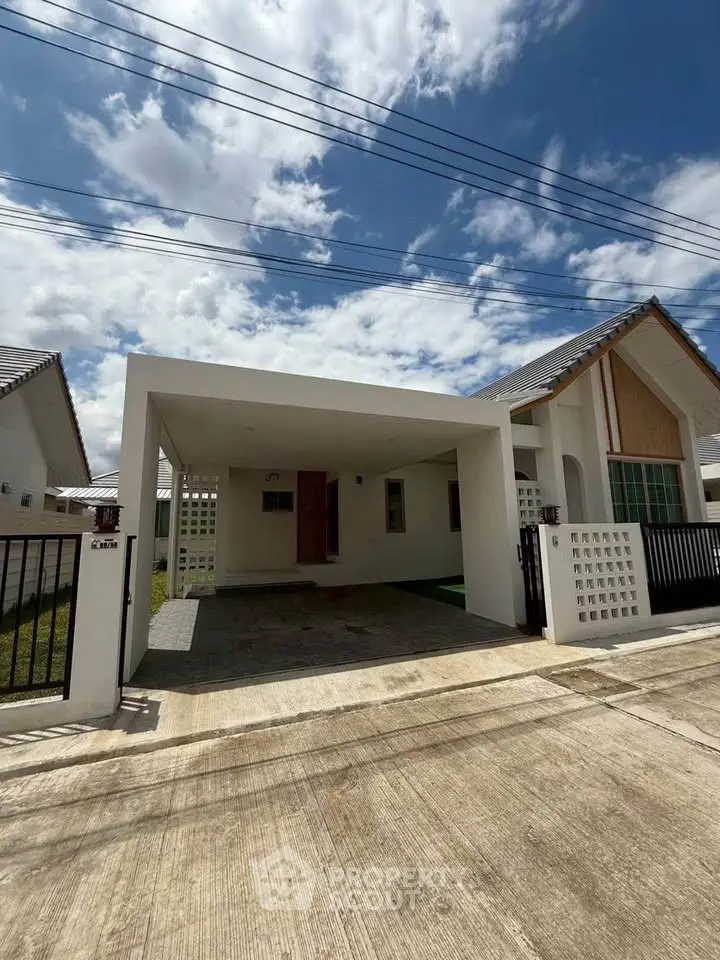 Modern single-story house with carport and minimalist design under a clear blue sky.