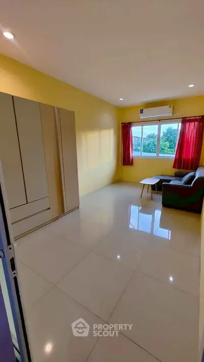 Bright living room with large window and minimalist furniture, perfect for cozy living.