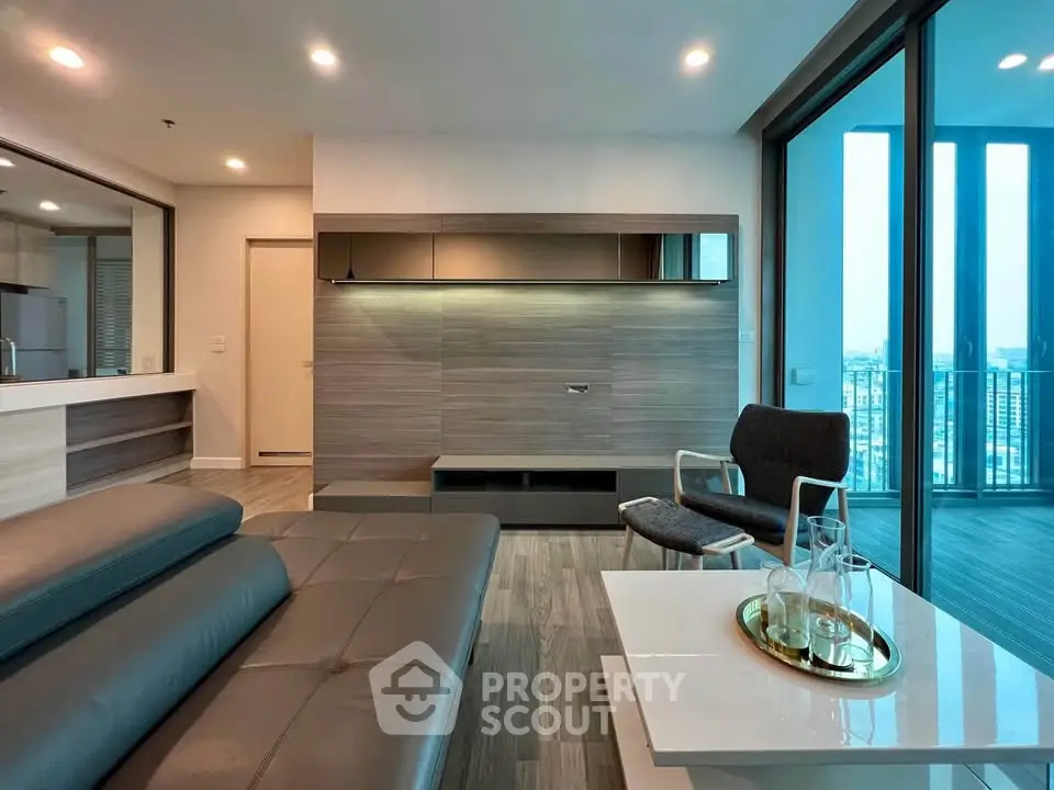 Modern living room with sleek furniture and large windows offering a stunning city view.
