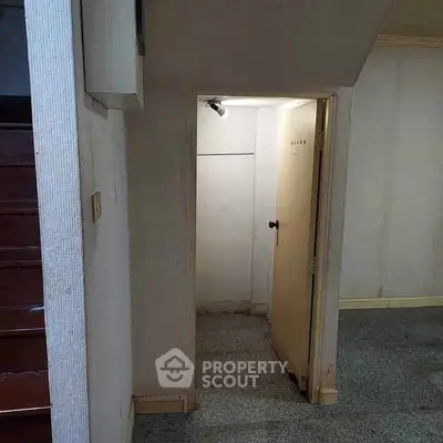 Cozy under-stair storage space with potential for creative use in a charming home.
