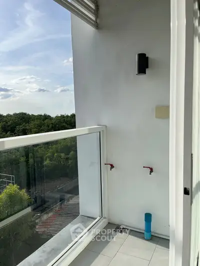 Modern balcony with glass railing and scenic view of greenery