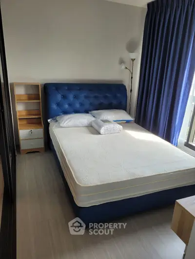 Modern bedroom with blue upholstered bed and natural light