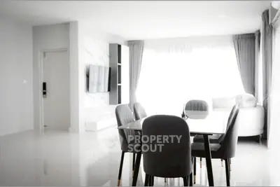 Modern open-plan living and dining area with sleek furniture and abundant natural light.
