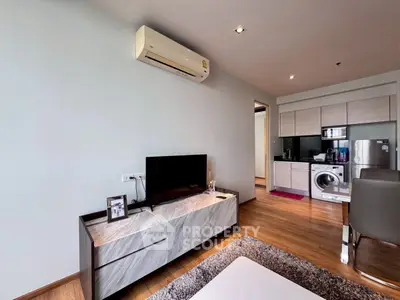 Modern living room with sleek furniture and open kitchen layout in a stylish apartment.