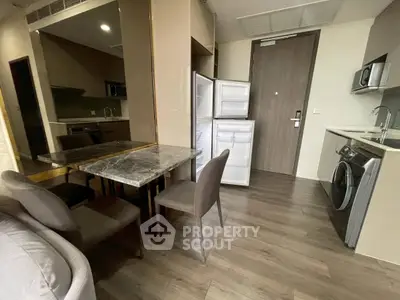 Modern apartment kitchen with open fridge and washing machine