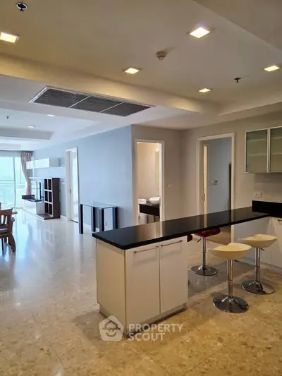 Spacious open-plan living area with modern kitchen and stylish bar stools.