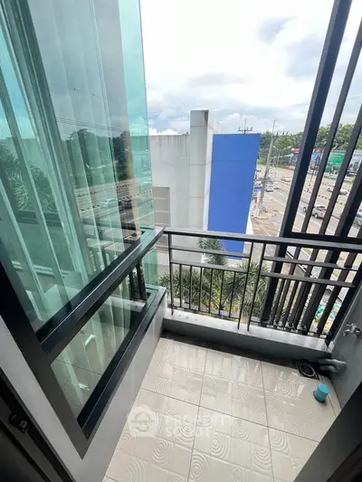 Modern balcony with glass railing offering urban city views, perfect for relaxation and enjoying the skyline.