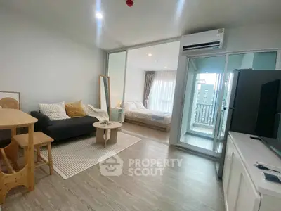 Modern open-plan living room with cozy bedroom and balcony view in stylish apartment.